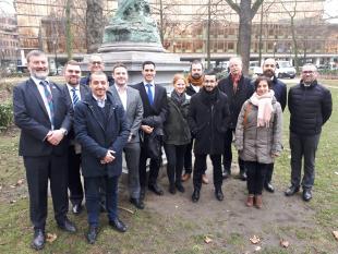 Project partners with the project officer standing  next to the statue of Atlas in the Square di Meeús, Ixelles, Brussels.